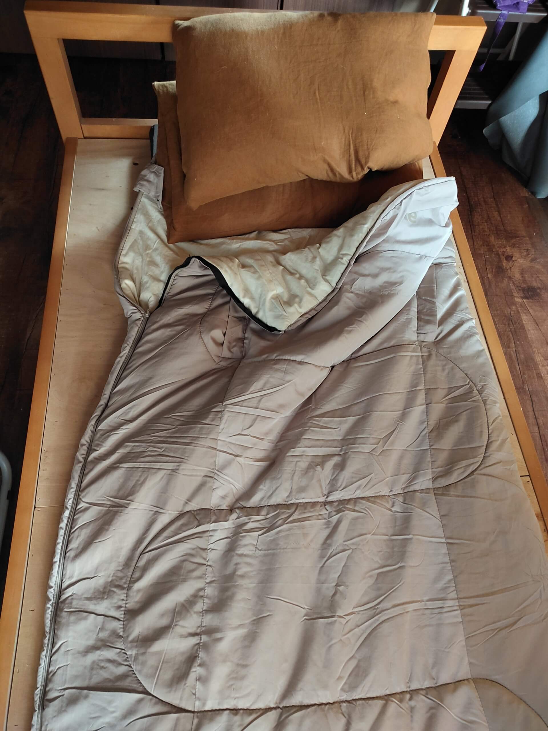 シングルベッドにセミシングルマットレス、その上に寝袋